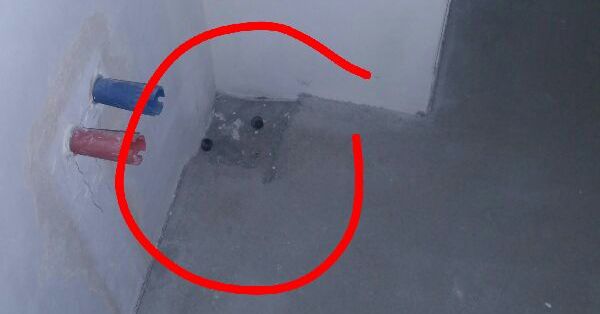 Zbliżenie na róg posadzki w łazience, gdzie widać zalany betonem odpływ kanalizacyjny, a odkrył to nasz specjalista na odbiorze technicznym w Bydgoszczy.