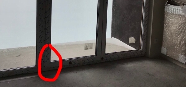 Na zdjęciu zaznaczono mostek termiczny, czyli nieszczelność okien balkonowych, która powoduje utratę ciepła. Możesz zamówić badanie kamerą termowizyjną podczas odbioru technicznego w Krakowie, żeby zareagować na taką usterkę.
